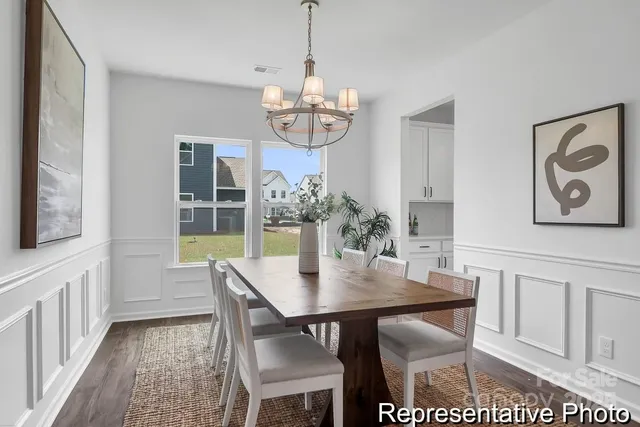 a view of a dining room with furniture a chandelier and wooden floor