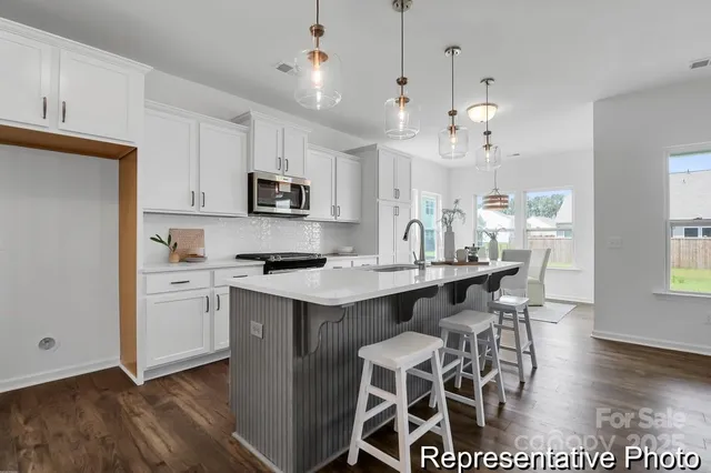 a kitchen with a dining table chairs and white cabinets
