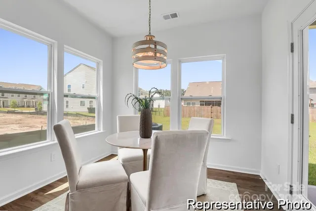 a dining room with furniture a chandelier and wooden floor