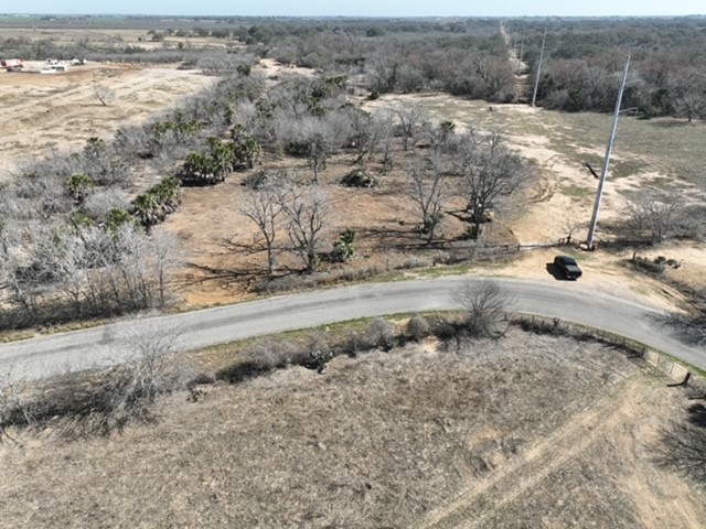 a view of a dry yard with wooden fence