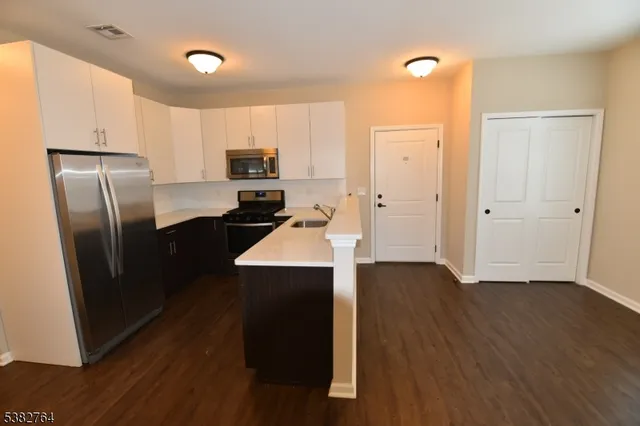 a kitchen with a refrigerator a sink and cabinets