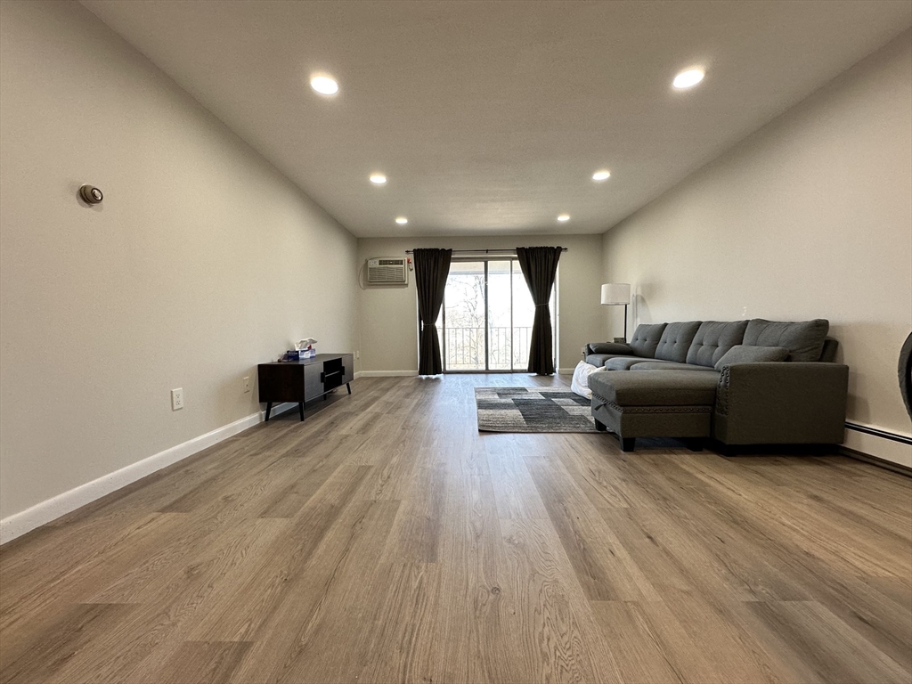 73 Charlesbank Road, Unit 306 Newton, MA 02458 - Photo 2 of 11 a living room with furniture and a wooden floor