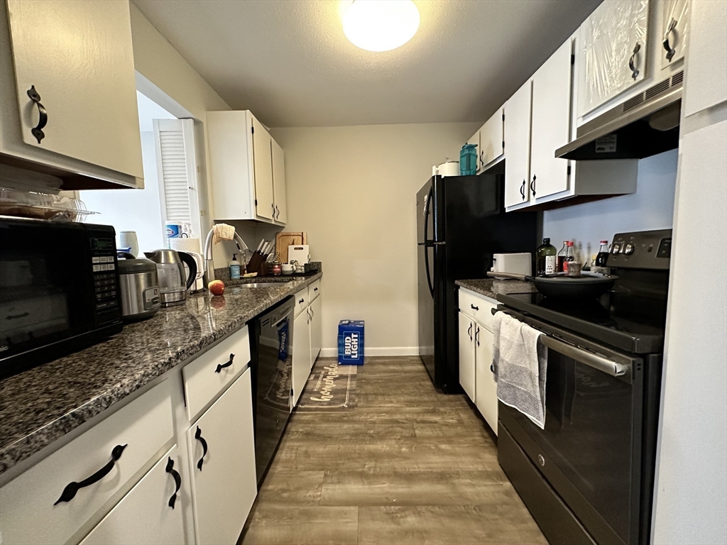 73 Charlesbank Road, Unit 306 Newton, MA 02458 - Photo 3 of 11 a kitchen with stainless steel appliances granite countertop a sink a stove and a refrigerator