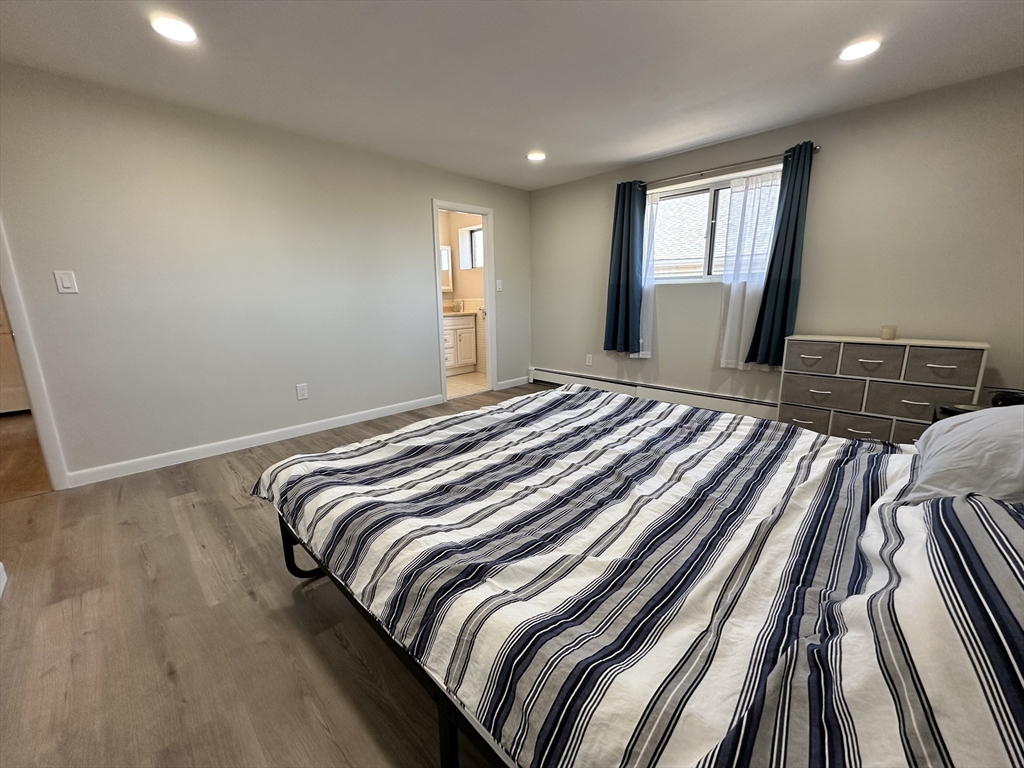 73 Charlesbank Road, Unit 306 Newton, MA 02458 - Photo 5 of 11 a bedroom with a bed and wooden floor