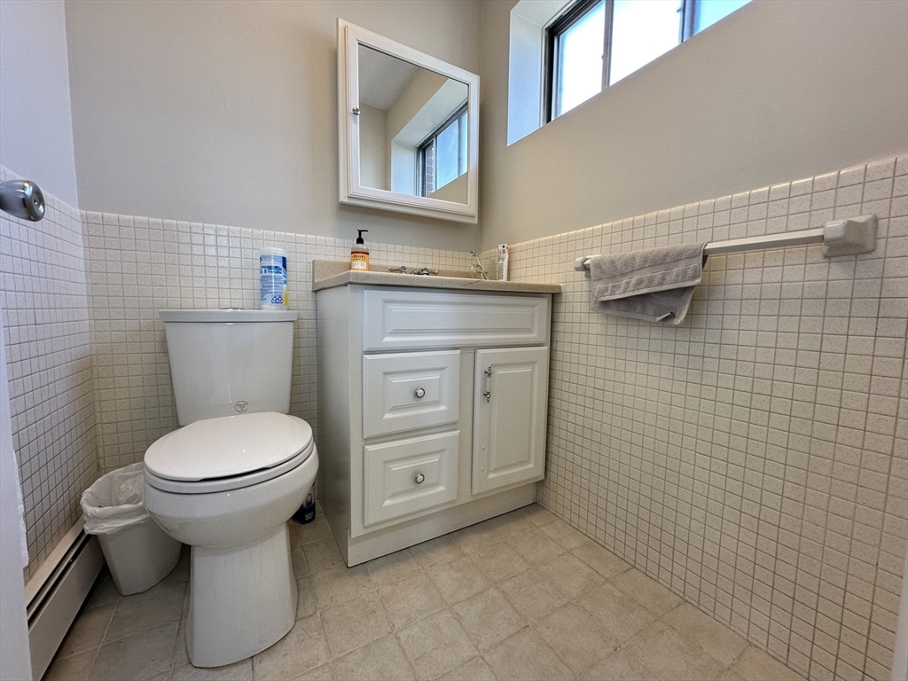 73 Charlesbank Road, Unit 306 Newton, MA 02458 - Photo 6 of 11 a bathroom with a toilet sink and mirror