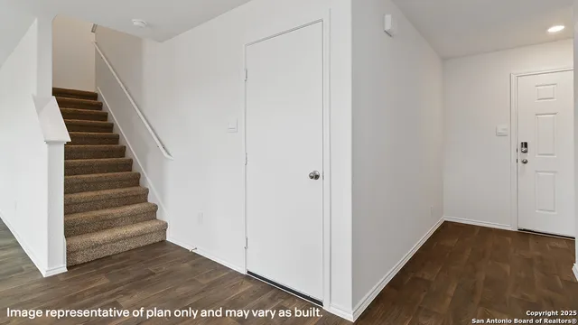a view of a hallway with wooden floor and entryway