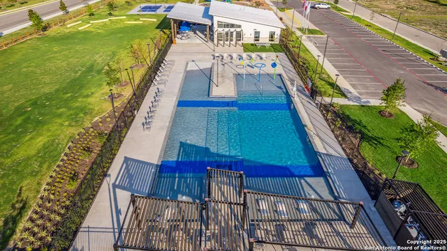 aerial view of a swimming pool with a yard and seating area