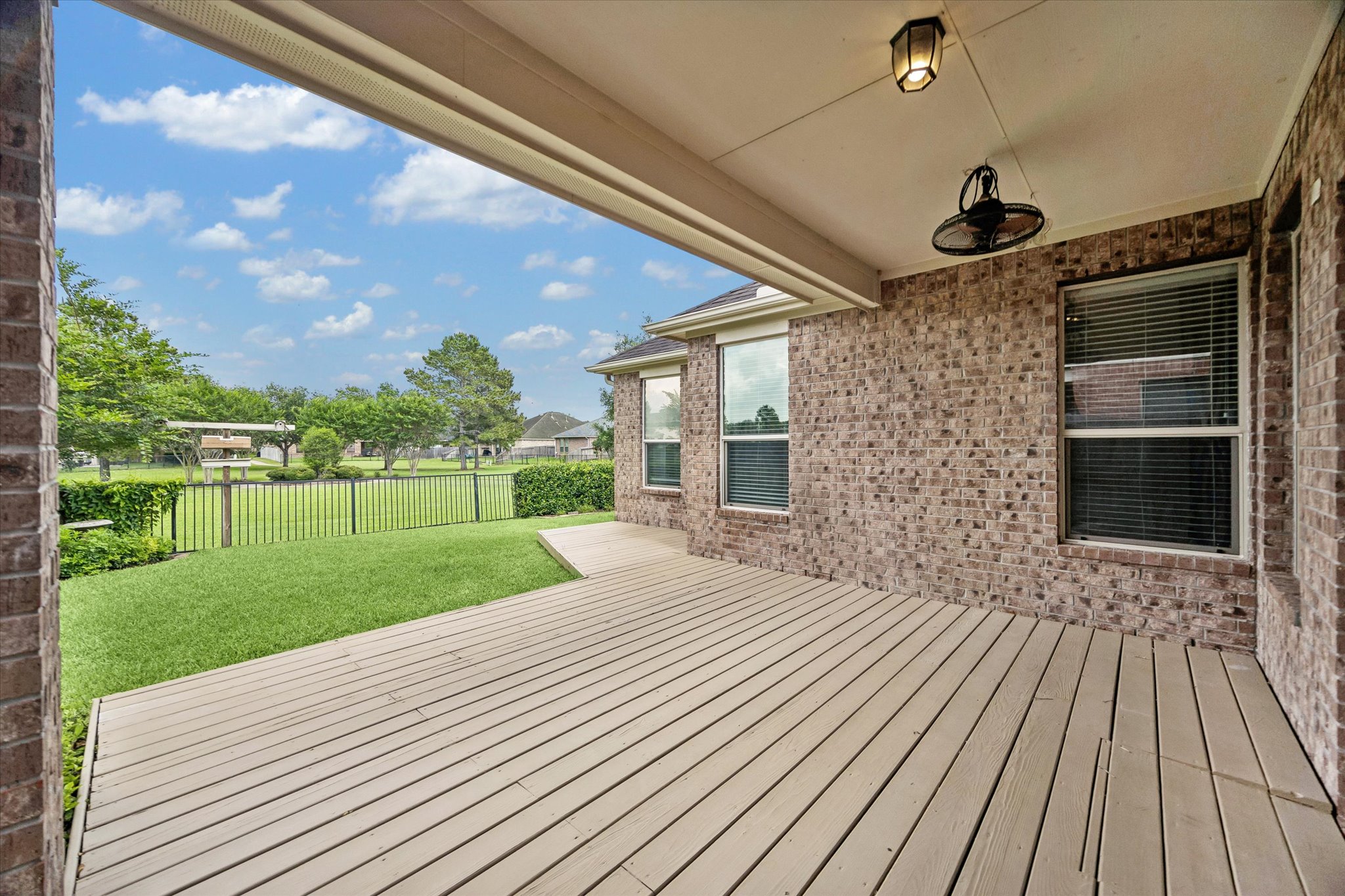 2214 Wembley Way Rosenberg, TX 77471 - Photo 16 of 35 Covered patio with wood-finish decking, brick exterior, and ceiling-mounted fan