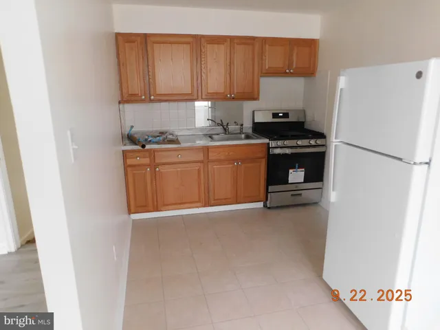 a kitchen with granite countertop a refrigerator a stove a sink and dishwasher with a refrigerator
