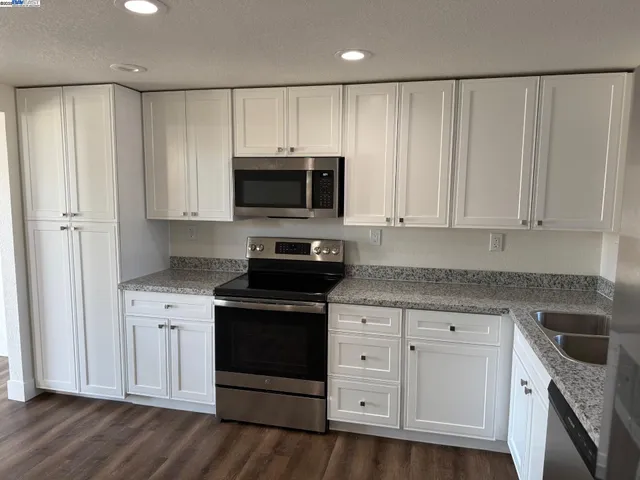 a kitchen with white cabinets and stainless steel appliances