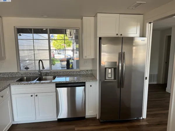 a kitchen with stainless steel appliances granite countertop a refrigerator and a sink