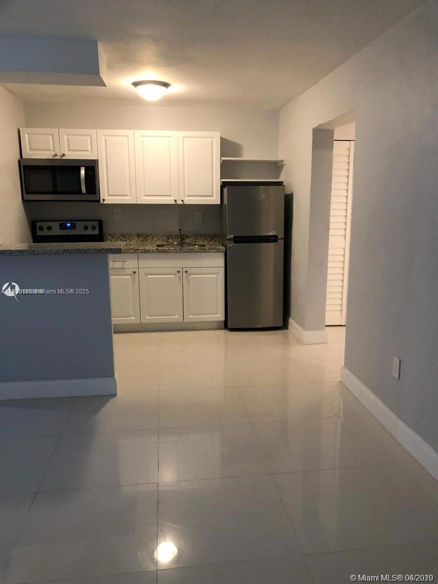 1479 Northwest 16th Street, Unit 2 Miami, FL 33125 - Photo 4 of 11 a kitchen with stainless steel appliances a refrigerator a stove a microwave and cabinets