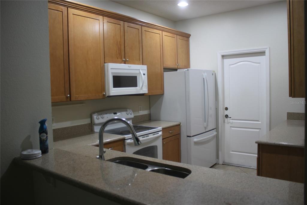 3222 Villa Strada Way Orlando, FL 32835 - Photo 3 of 26 a kitchen with stainless steel appliances a microwave a sink and a refrigerator