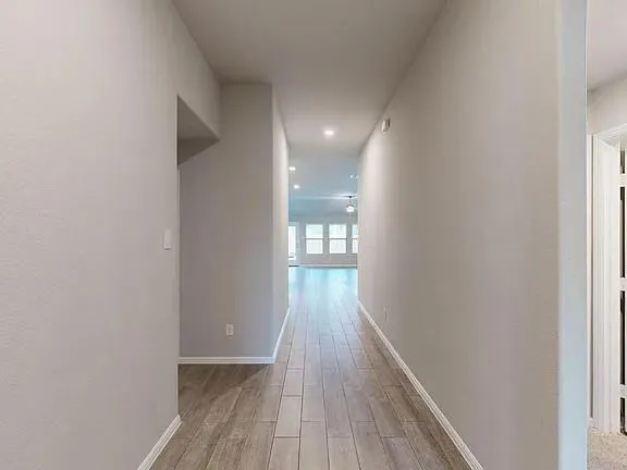 a view of a hallway with wooden floor