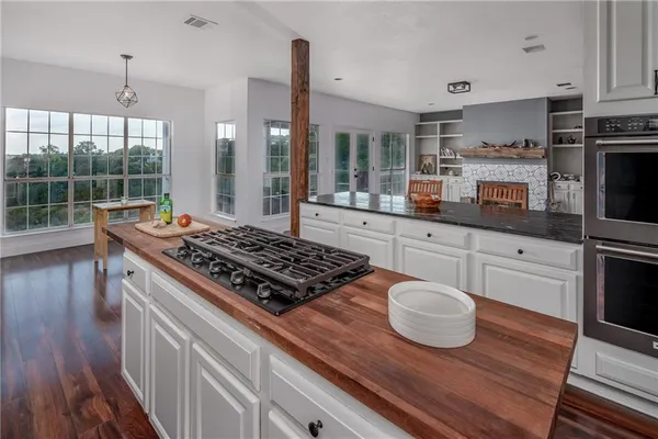 a kitchen with a stove and wooden floor