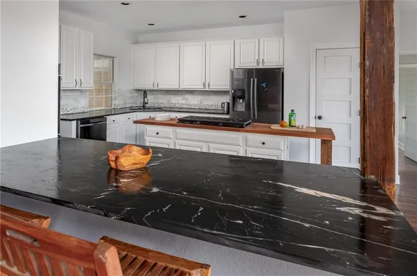 a kitchen with kitchen island granite countertop a stove and a refrigerator