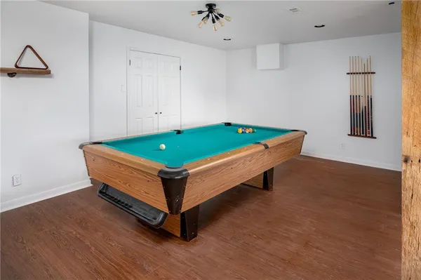 a room with wooden floor and pool table