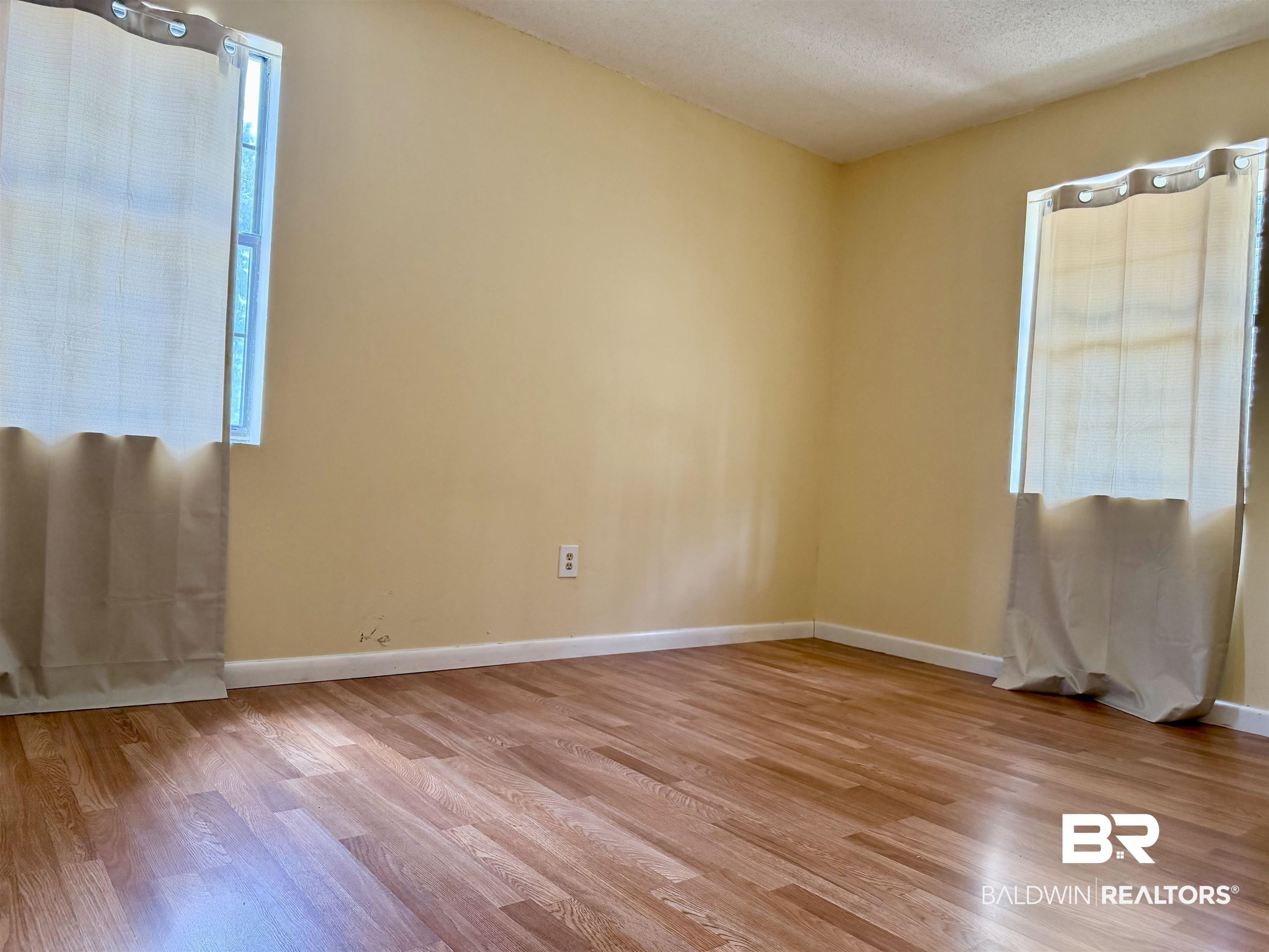 294 Wolf Log Road Flomaton, AL 36441 - Photo 11 of 14 Spare room featuring light wood-style floors, plenty of natural light, and a textured ceiling