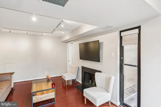 a living room with furniture a flat screen tv and a fireplace