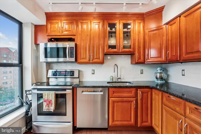 a kitchen with stainless steel appliances granite countertop a stove and a microwave