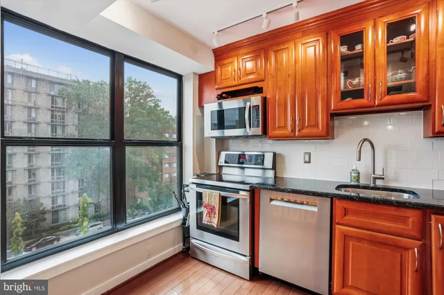 a kitchen with stainless steel appliances granite countertop a stove a sink and a microwave
