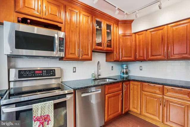 a kitchen with stainless steel appliances granite countertop a stove microwave and cabinets