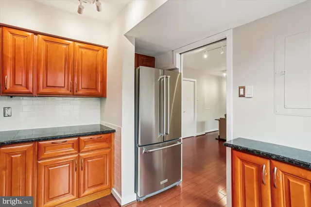 a kitchen with stainless steel appliances granite countertop a refrigerator and a sink