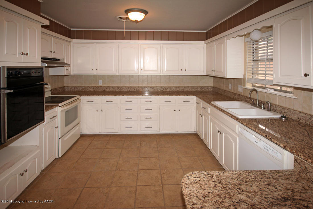 7203 Elmhurst Road Amarillo, TX 79106 - Photo 11 of 30 a kitchen with granite countertop a sink a stove and cabinets