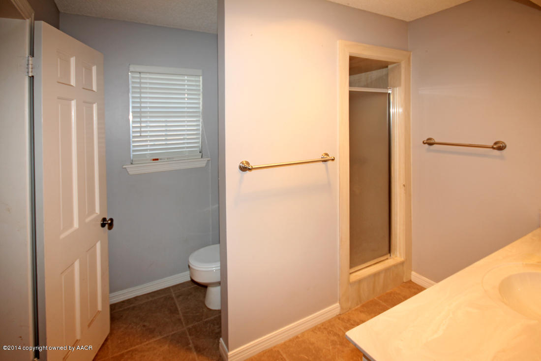 7203 Elmhurst Road Amarillo, TX 79106 - Photo 17 of 30 a bathroom with a granite countertop shower and a toilet