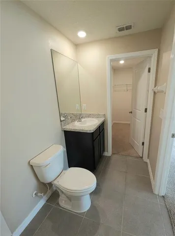 a bathroom with a sink a toilet a mirror and vanity