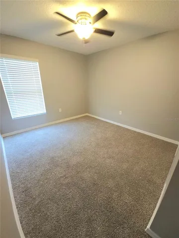 en empty room with windows and fan