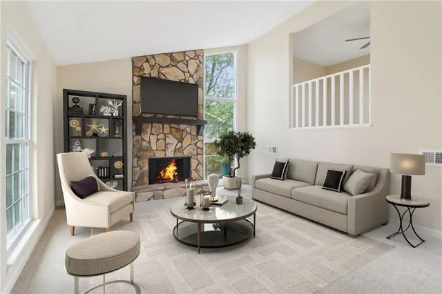 a living room with furniture a flat screen tv and a fireplace