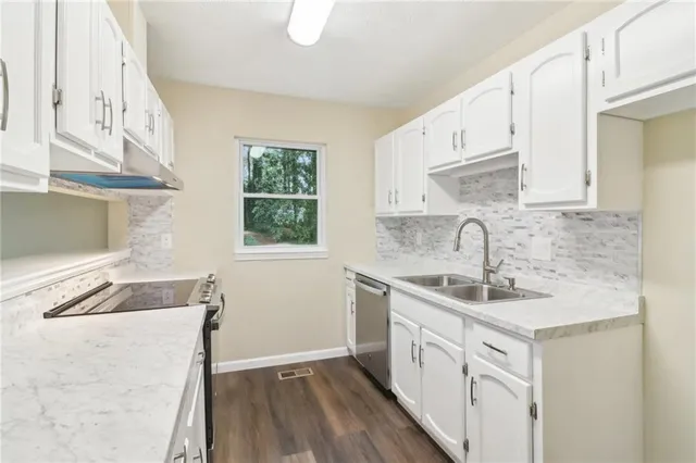 a kitchen with a sink stove and cabinets