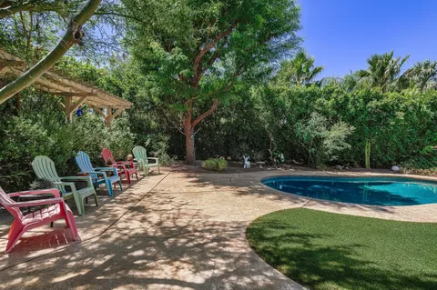 a view of backyard with swimming pool and sitting area