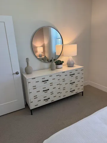 a view of a livingroom with furniture and mirror in it