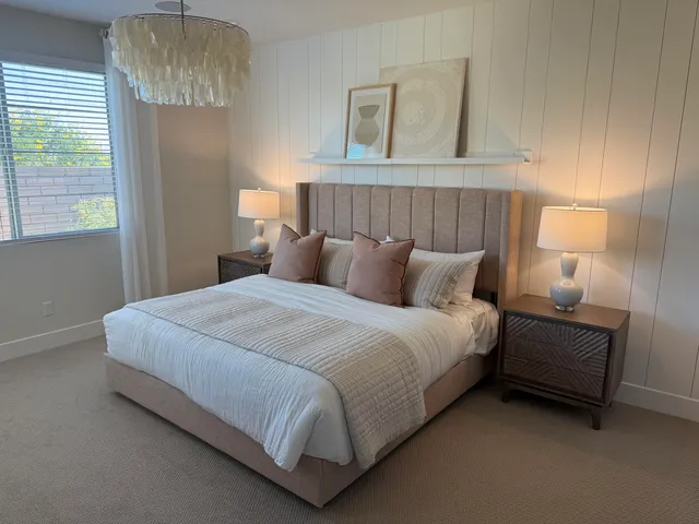 a large bed sitting in a bedroom next to a window