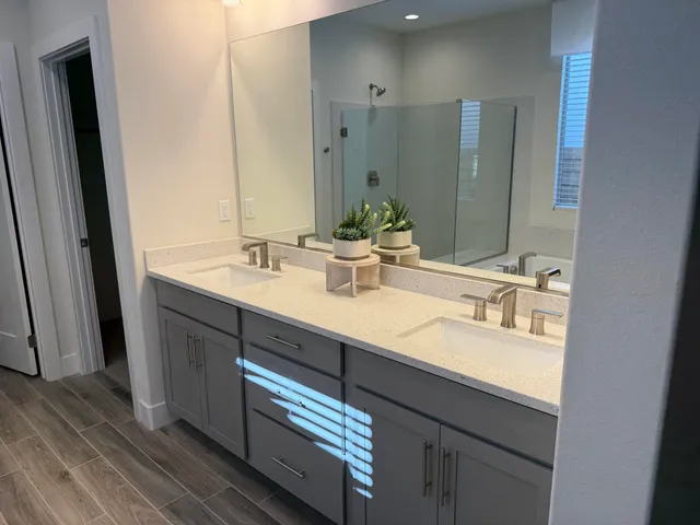 a bathroom with a double vanity sink and a mirror
