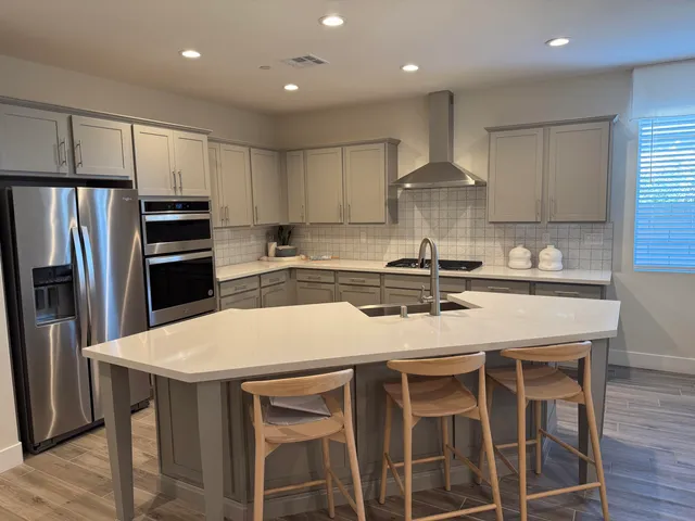 a kitchen with kitchen island granite countertop a sink and stainless steel appliances