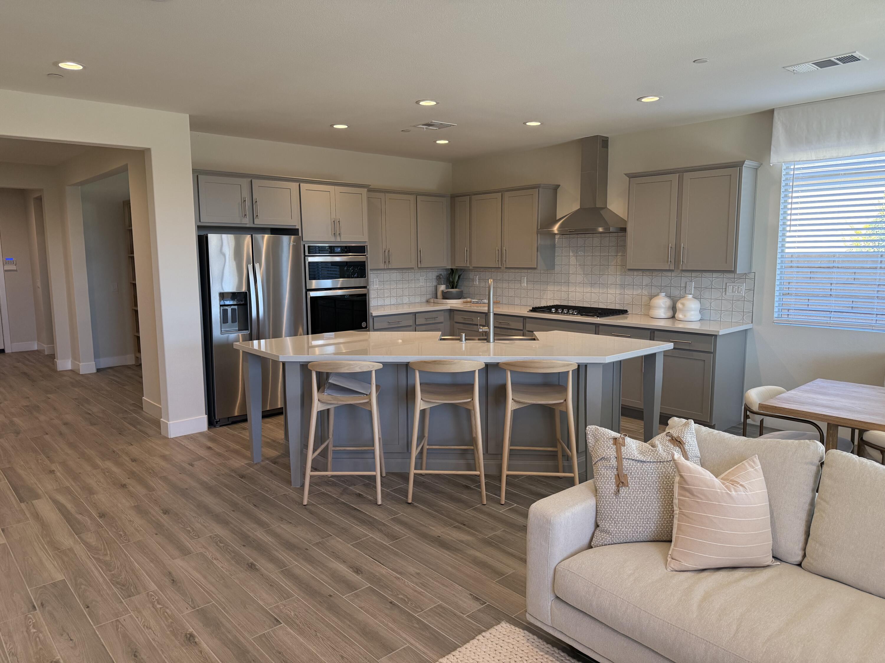 39912 Felicita Parkway Palm Desert, CA 92211 - Photo 5 of 32 a living room with stainless steel appliances granite countertop furniture wooden floor and a kitchen view