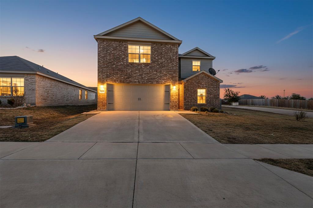 Traditional home with concrete driveway, an attached garage, stone siding, and brick siding