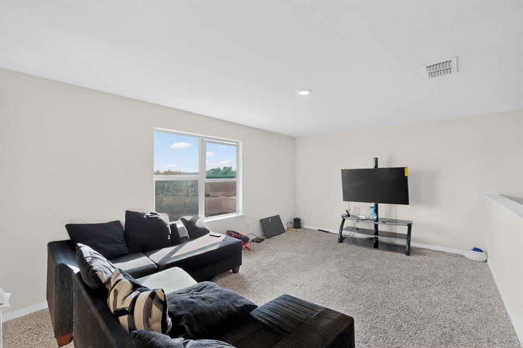 148 Point Rider Road Newark, TX 76071 - Photo 16 of 40 Carpeted living area with baseboards