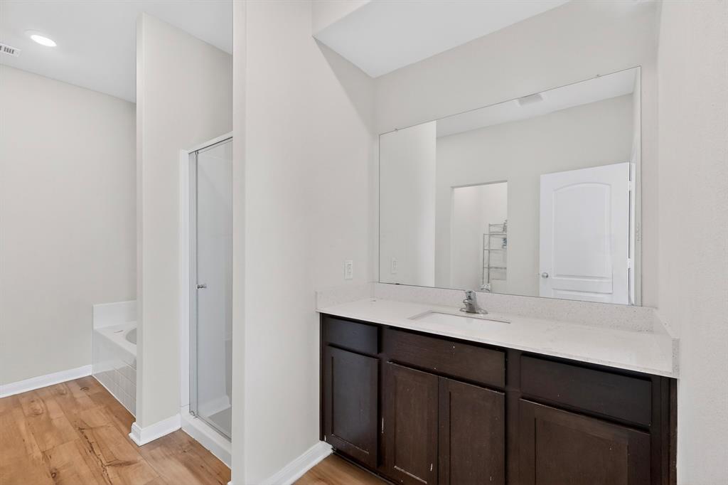 148 Point Rider Road Newark, TX 76071 - Photo 22 of 40 Bathroom with a stall shower, vanity, a bath, and light wood finished floors