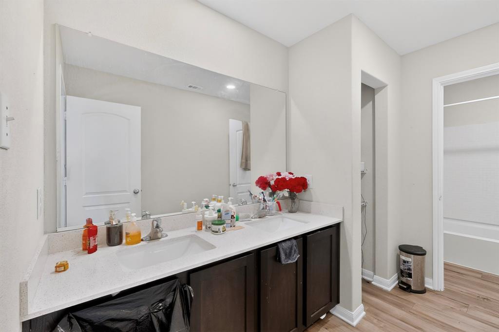 148 Point Rider Road Newark, TX 76071 - Photo 29 of 40 Bathroom with double vanity, light wood-type flooring, and bathing tub / shower combination