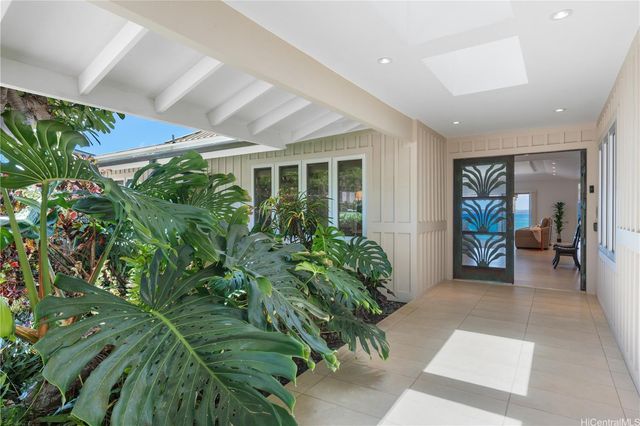 a living room with furniture kitchen view and a large window