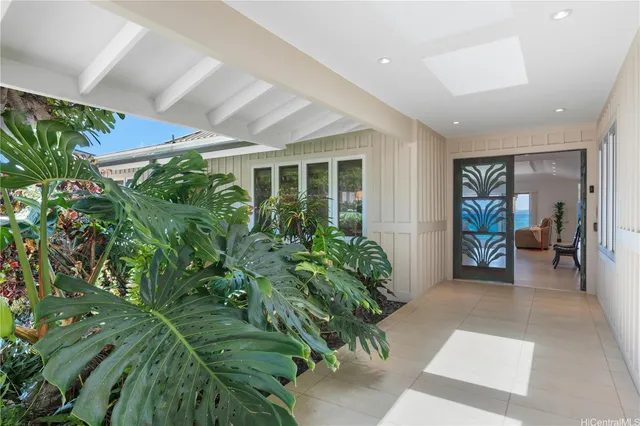 a living room with furniture kitchen view and a large window