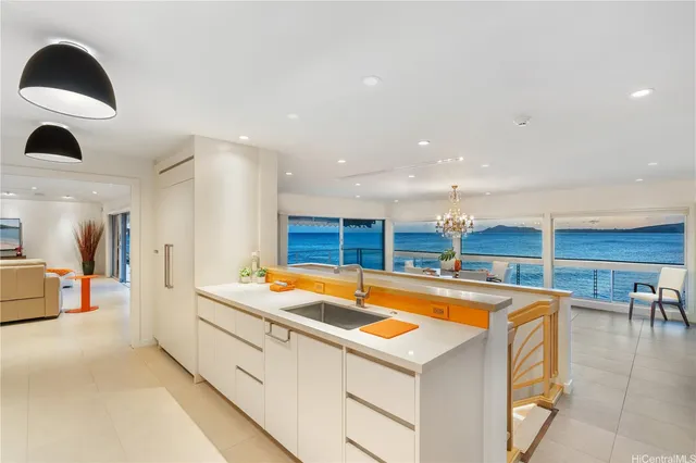 a view of house with ocean view and a wooden deck