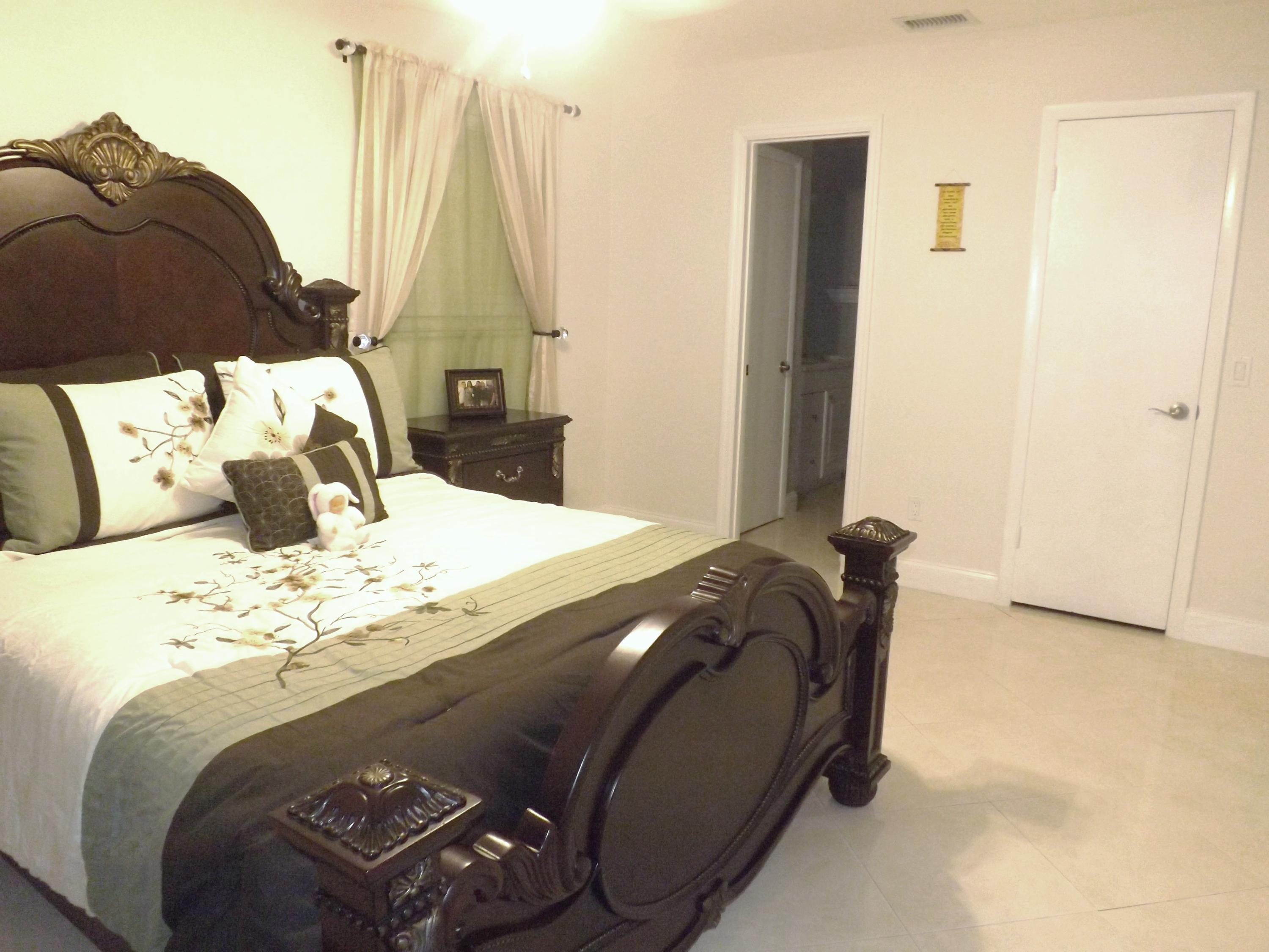 64 Davis Road Palm Springs, FL 33461 - Photo 12 of 32 a bedroom with a bed and a window
