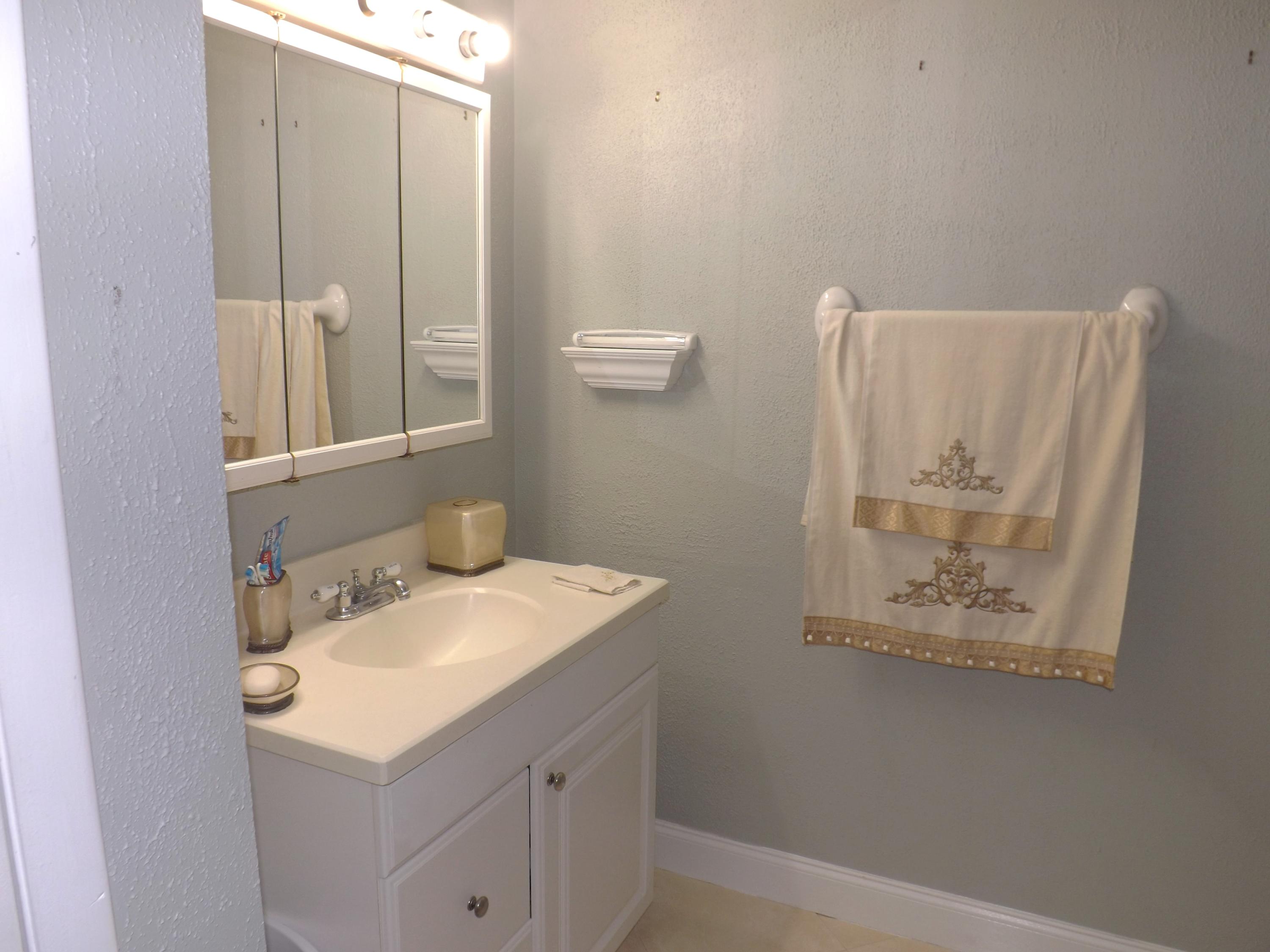 64 Davis Road Palm Springs, FL 33461 - Photo 13 of 32 a bathroom with a sink and a mirror