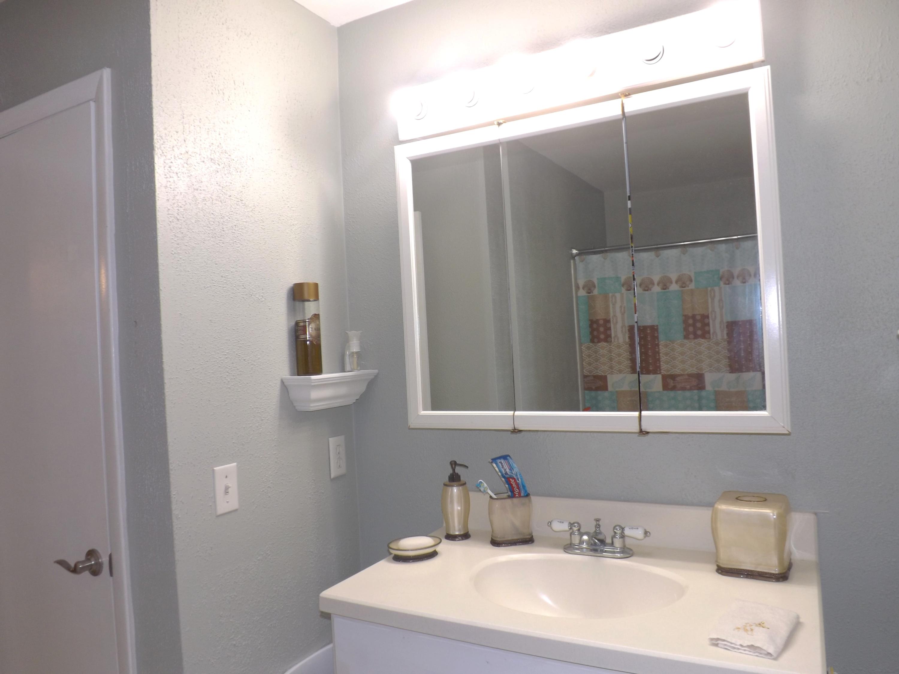 64 Davis Road Palm Springs, FL 33461 - Photo 14 of 32 a bathroom with a sink and mirror with toilet