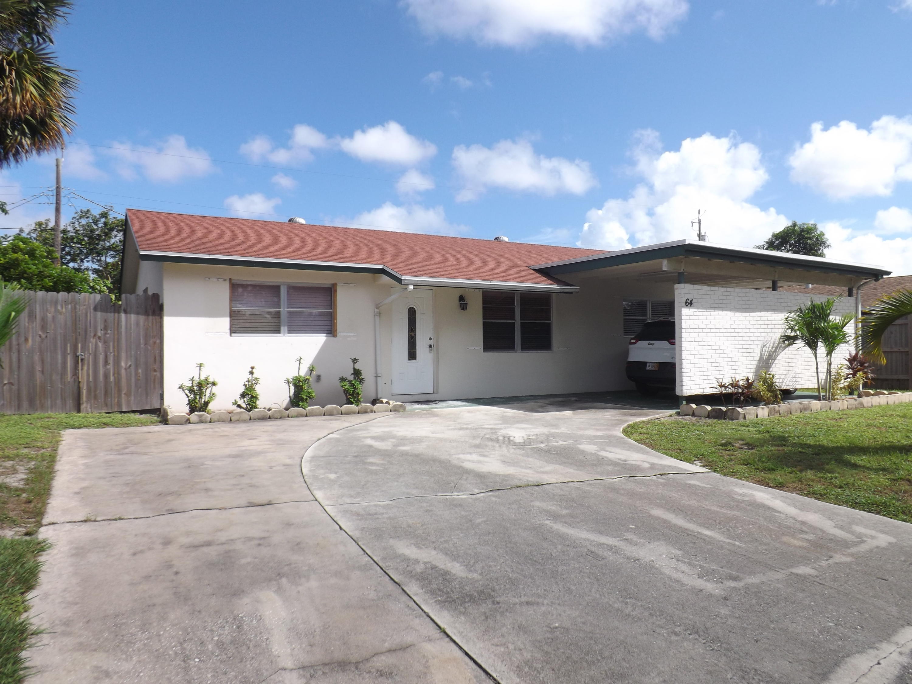 64 Davis Road Palm Springs, FL 33461 - Photo 2 of 32 a front view of a house with a yard and garage